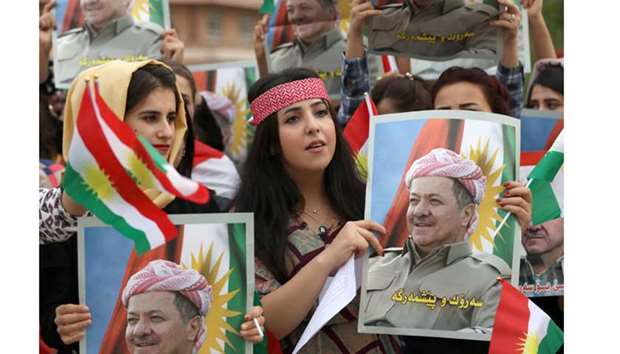 Iraqi Kurdish students of the Salahaddin University hold posters of  Kurdish leader Massoud Barzani during a protest in his support in Arbil, yesterday.