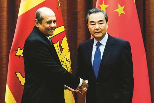 Chinese Foreign Minister Wang Yi, right, and Sri Lankau2019s Foreign Minister Tilak Marapana shake hands before their meeting at the Ministry of Foreign Affairs in Beijing yesterday.