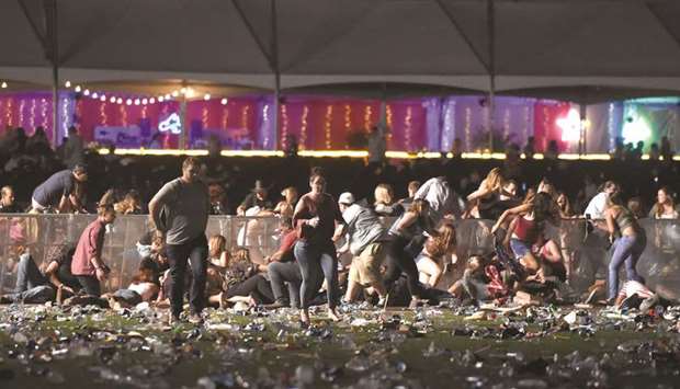 People scramble for shelter at the Route 91 Harvest country music festival on Sunday night amid gunfire.