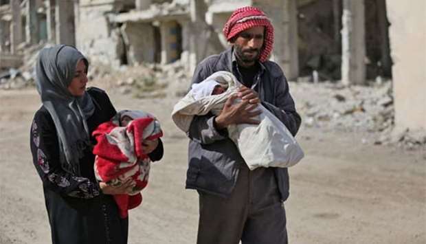 Umm Mohammed and her husband carry their toddlers who suffer from malnutrition in the town of Al-Nashabiyah in the besieged rebel-held Eastern Ghouta region outside Syria's capital Damascus.