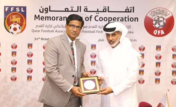 Sheikh Hamad bin Khalifa bin Ahmed al-Thani, President of the QFA presents a memento to Anura De Silva, chief of the Football Federation of Sri Lanka in Doha yesterday.