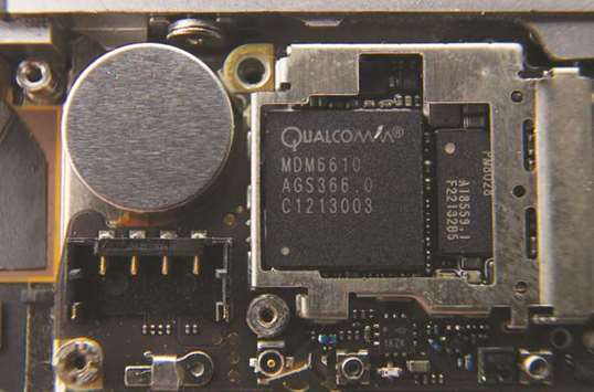 A Qualcomm baseband processor is seen inside an Iphone 4S. Apple made the decision not to use Qualcomm modem chips for 2018 models amid a dispute over the iPhone makeru2019s access to the San Diego-based companyu2019s proprietary technology, say people familiar with the matter.