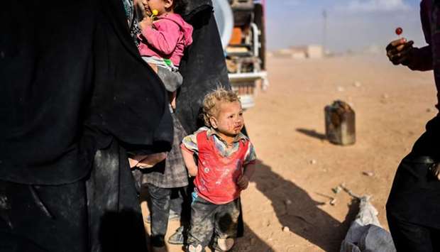 Syrians displaced from the city of Deir Ezzor gather on the outskirts of Raqqa yesterday.