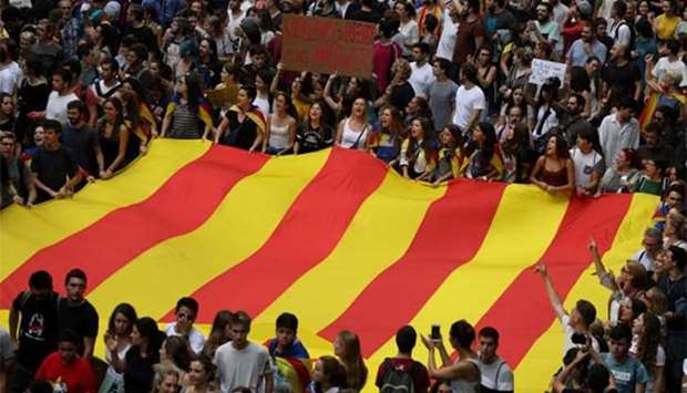 People carry a huge flag and placards during a demonstration two days after the banned independence referendum, in Barcelona on Tuesday.