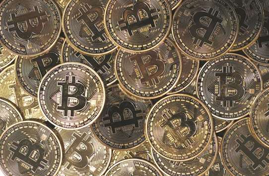A collection of bitcoin tokens are arranged for a photograph in London. Instead of speculating on bitcoin, the smart money has figured out that one of the surest ways to get rich quickly with cryptocurrencies is to be in early on initial coin offerings.
