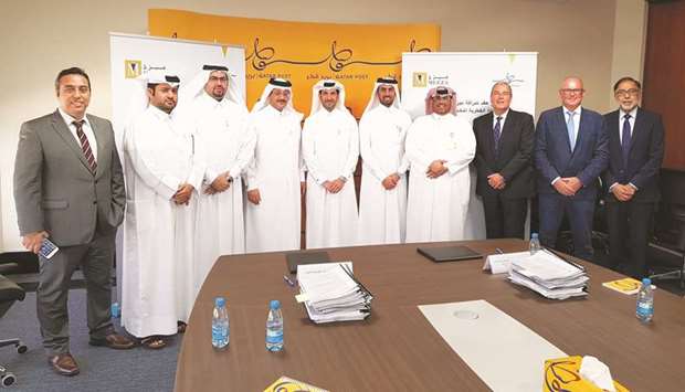 Meeza and Qatar Post officials pose for a photo after announcing their partnership.
