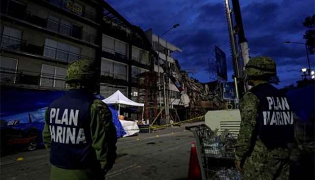 Mexican Marines stand guard near a building that collapsed in an earthquake after rescue teams retrieved the last body trapped in the rubble, in Mexico City on Wednesday.