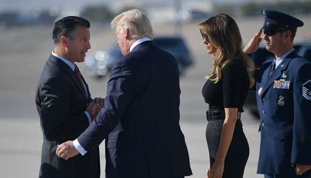 Nevada Governor Brian Sandoval (L) greets US President Donald Trump and First Lady Melania Trump upon their arrival at McCarran International Airport in Las Vegas.