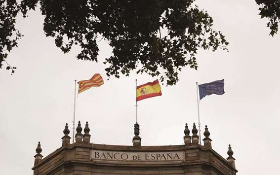 Catalonian, Spanish and European flags fly on the roof of the Bank of Spain, three days after the banned independence referendum, in Barcelona yesterday. Madridu2019s main index, the Ibex, fell nearly 3% to 9,964.90 points at the close after falling below the key 10,000 level.