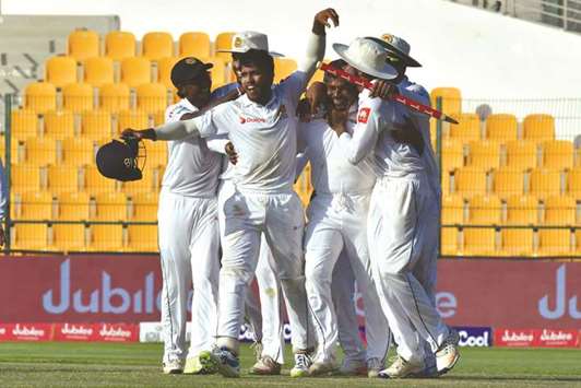 Sri Lankan players celebrate after victory on the fifth day of the first Test match against Pakistan in Abu Dhabi on October 2. (AFP)