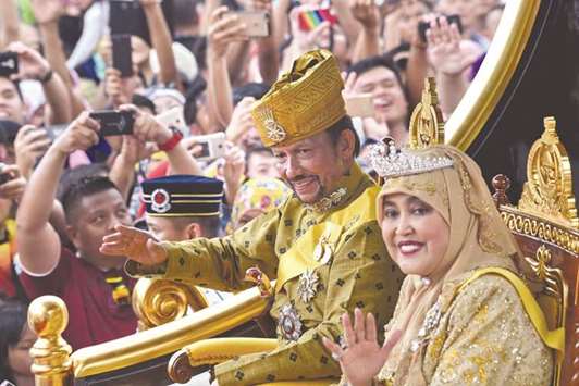 Bruneiu2019s Sultan Hassanal Bolkiah and Queen Saleha ride in a royal chariot during a procession to mark the golden jubilee of his accession to the throne in Bandar Seri Begawan.