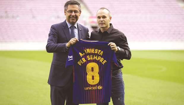 Andres Iniesta (right) poses with a special Barcelona FC jersey next to the Catalan clubu2019s president Josep Maria Bartomeu at the Camp Nou in Barcelona yesterday. (AFP)