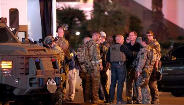 FBI agents confer in front of the Tropicana hotel-casino on October 2, 2017, after a mass shooting during a music festival on the Las Vegas Strip in Las Vegas.