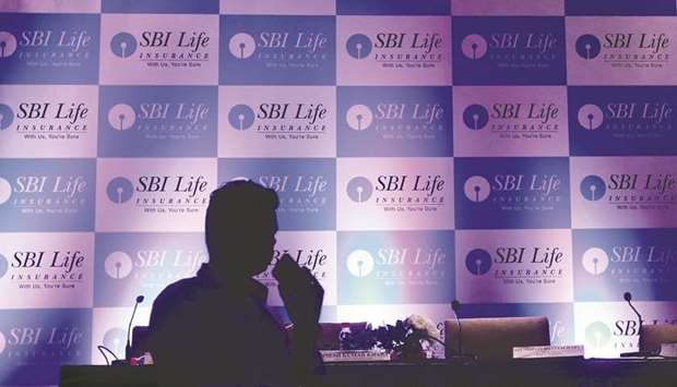 A man walks past a podium set up at the venue of a news conference to announce the launch of initial public offering by SBI Life Insurance in Mumbai. After the IPO, SBI Life is valued at $10.8bn.