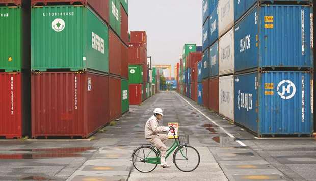 A worker rides a bicycle in a container area at a port in Tokyo. Japanu2019s economy expanded at an annualised 2.5% in the second quarter as consumer and company spending picked up, with steady growth likely to be sustained in coming quarters.