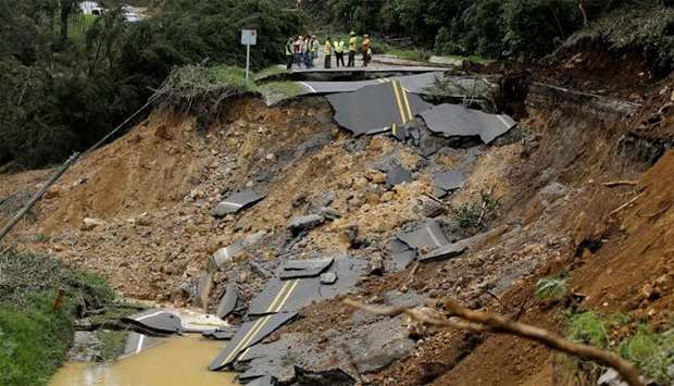 People look at a highway, that connects with the south of the country, collapsed by Storm Nate in Casa Mata, Costa Rica