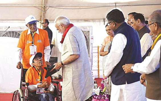 Prime Minister Narendra Modi felicitates one of the trainees under the Pradhan Mantri Gramin Digital Saksharta Abhiyan scheme at the dedication ceremony of the newly constructed building of the Indian Institute of Technology IIT, Gandhinagar in Gujarat yesterday.