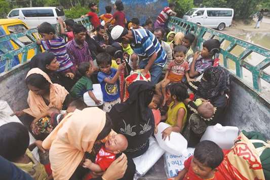 Rohingya refugees are seen atop a truck before being shift to a refugee camp following their arrival after crossing the border from Myanmar into Bangladesh in Teknaf yesterday.