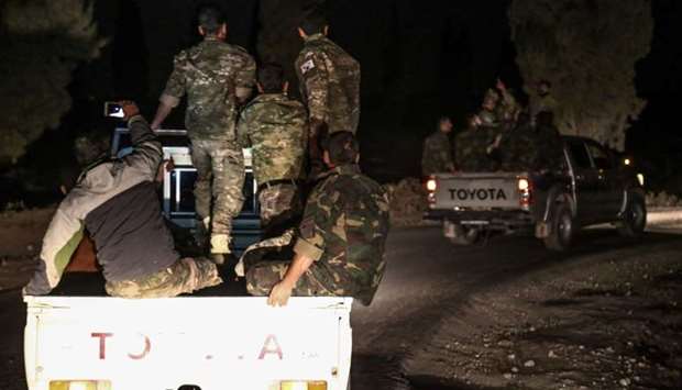 Pro-Ankara Syrian rebel fighters are seen riding on pickup trucks near the village of Hawar Killis along the Syrian-Turkish border in the northern province of Aleppo on October 6, 2017, as they advance towards jihadist-controlled Idlib province.