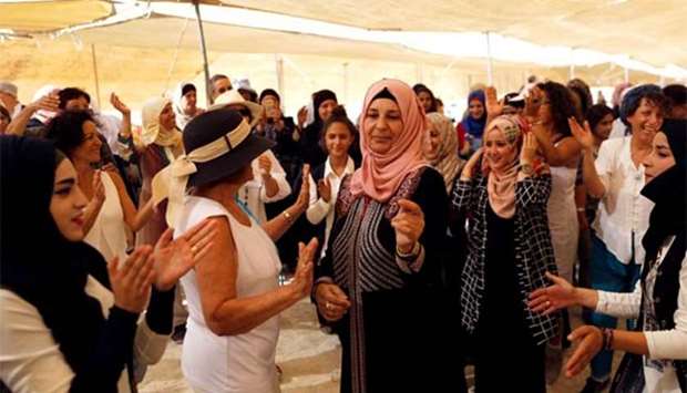 Palestinian and Israeli women celebrate inside a ,peace tent, erected as part of an event organised by ,Women Wage Peace, group near the Jordan River, in the occupied West Bank, on Sunday.