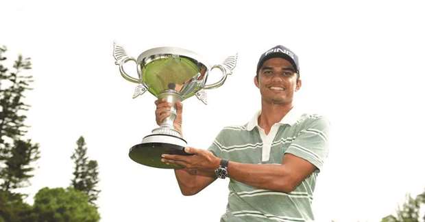 Indiau2019s Ajeetesh Sandhu poses with the trophy after winning Yeangder Tournament Players Championship in Taiwan yesterday.