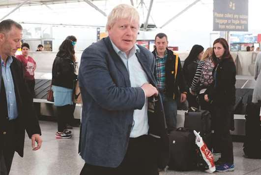 Foreign Secretary Boris Johnson collects his baggage at London Stansted Airport, north of London, yesterday.