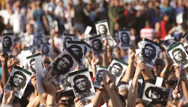 People hold pictures of late Cuban revolutionary hero Ernesto u201cCheu201d Guevara during a ceremony commemorating the 50th anniversary of his death in Santa Clara, Cuba, yesterday.