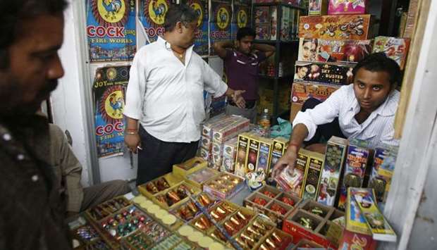 An Indian fireworks vendor serving customers at his shop in New Delhi