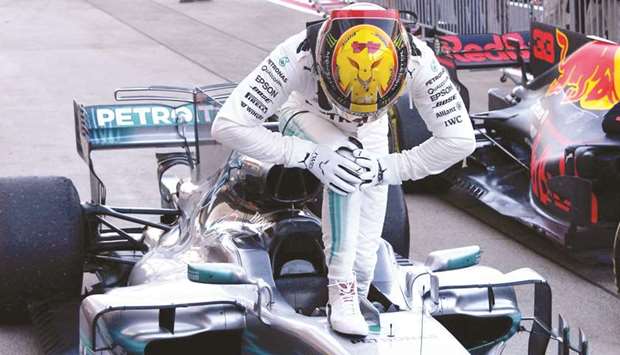 Mercedesu2019 British driver Lewis Hamilton stands on his car in celebration of his victory after returning to the parc ferme in the Formula One Japanese Grand Prix at Suzuka on October 8. (AFP)