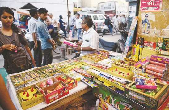 A woman looks on at a shop selling firecrackers in New Delhi yesterday. Indiau2019s top court ordered a temporary ban on the sale of firecrackers in the capital ahead of the Diwali festival that leaves the city shrouded in toxic smog.