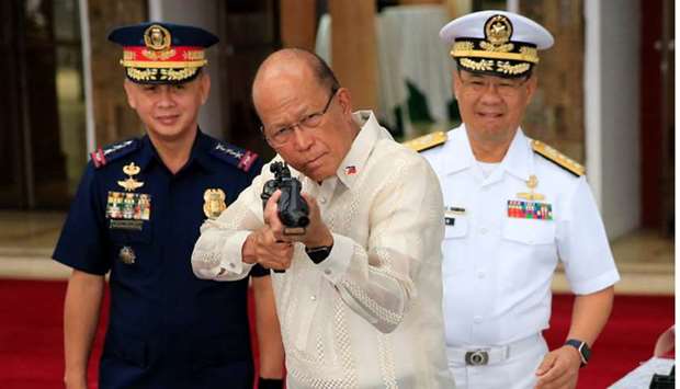Philippine Defense Secretary Delfin Lorenzana (C), aim an automatic rifle during the turnover ceremony of China's urgent military assistance to the Philippines at the military camp in Camp Aguinaldo in Quezon city, metro Manila, Philippines.