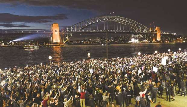 Demonstrators are seen protesting against the decision to project the barrier draw results for Racing NSWu2019s multi-million dollar race, The Everest, onto the sails of the Opera House, in Sydney, Australia, yesterday.