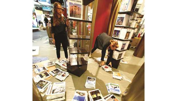 Staffers arrange books on shelves at the book fair.