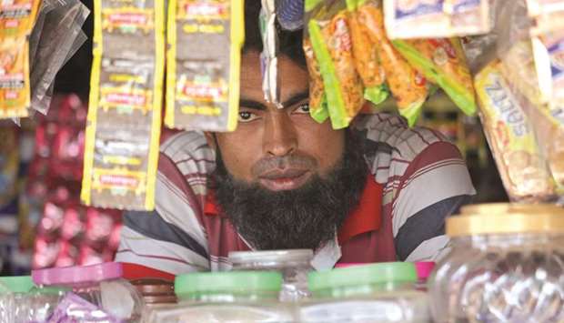 A man from the Rohingya community looks on as he sits inside his shop at a camp on the outskirts of Jammu.