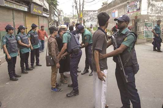 Police inspect pedestrians near the special court, following verdict in the cases filed over August 21, 2004 grenade attack, in Dhaka yesterday.