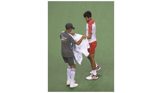 Serbiau2019s Novak Djokovic using a towel during his menu2019s singles first round match at the Shanghai Masters on Tuesday. (AFP)