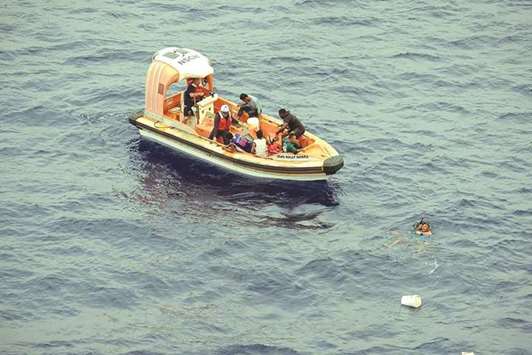 Philippine fishermen, whose boat was sunk by a marlin, being rescued by US Navy personnel onto a craft from the USS Wally Schirra in the South China Sea.