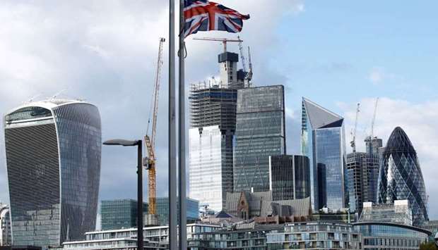 British flag flutters in the wind with the financial district in the background, in London