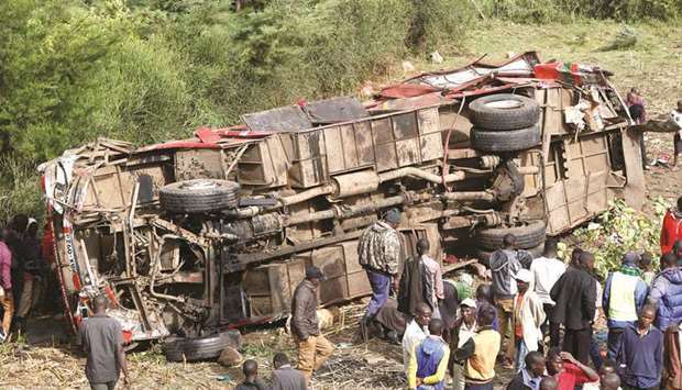 Residents look at the wreckage of a bus that crashed, near Fort Ternan along the Londiani-Muhoroni road in Kericho county, yesterday.