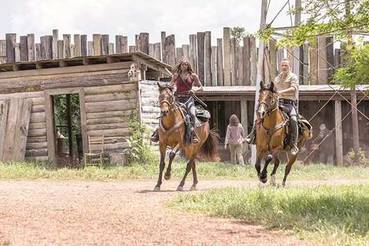 PREMIER: Itu2019s back to horses and wooden houses on The Walking Dead, starring Andrew Lincoln as Rick Grimes, right, and Danai Gurira as Michonne.