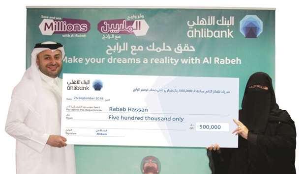 Ahlibank deputy CEO (Retail and Private Banking) Hassan AlEfrangi hands over the ceremonial cheque to Abu Hamour Branch customer Rabab Hassan during a ceremony held under the presence of a representative from the Ministry of Economy and Commerce.