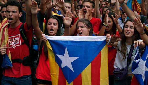 Students hold a Catalan pro-independence 'Estelada' flag during a demonstration to commemorate the anniversary of a banned referendum on secession that was marred by police violence.