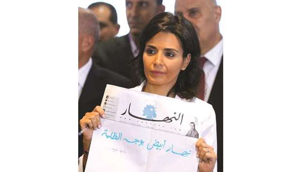 An-Naharu2019s editor-in-chief Nayla al-Tueni holds a blank edition of the newspaper during a news conference in Beirut yesterday.