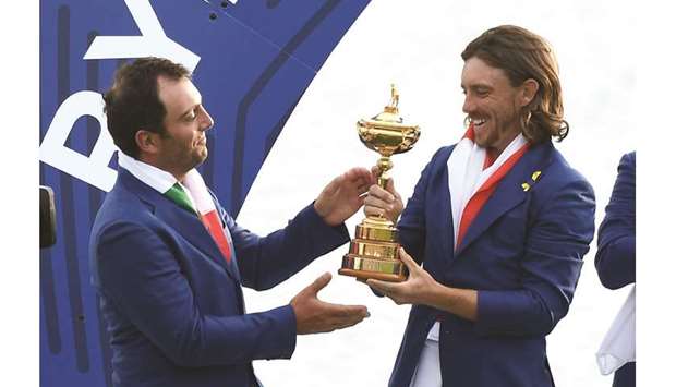 Europeu2019s English golfer Tommy Fleetwood and Italian golfer Francesco Molinari (left) hold the trophy as they celebrate winning the 42nd Ryder Cup at Le Golf National Course at Saint-Quentin-en-Yvelines, south-west of Paris, on Sunday. (AFP)