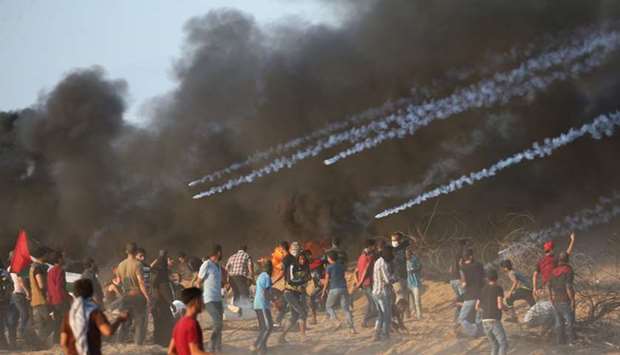 Tear gas canisters are fired by Israeli troops towards Palestinian demonstrators during a protest calling for lifting the Israeli blockade on Gaza and demanding the right to return to their homeland, at the Israel-Gaza border fence in the southern Gaza Strip.
