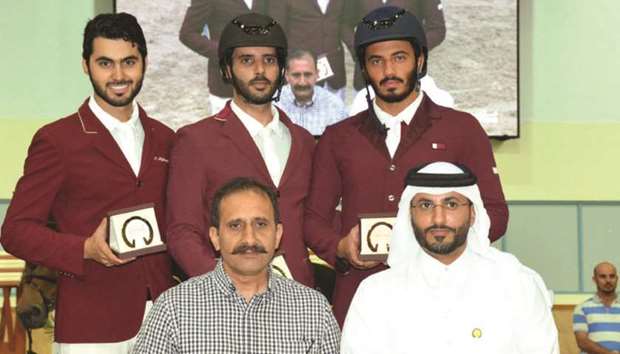 Medium Tour winner Mubarak Yousuf al-Rumaihi (rear, centre), runner-up Nasser al-Ghazali (rear, left) and third-placed Saeed Nasser al-Qadi (rear, right) pose with officials at Qatar Equestrian Federationu2019s Indoor Arena yesterday. PICTURE: Lotfi Garsi