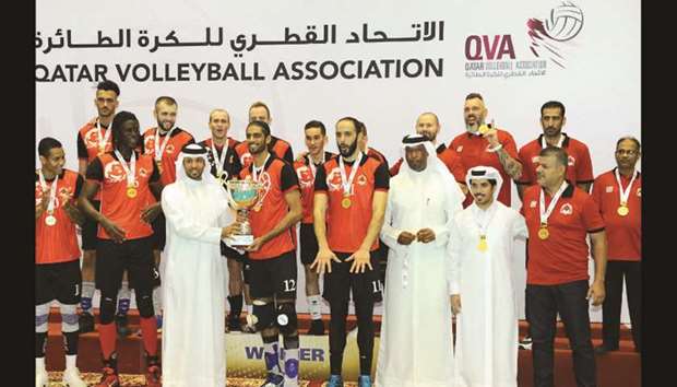 Qatar Volleyball Association (QVA) president Ali Ghanim al-Kuwari presents the Super Cup trophy to Al Rayyan captain Mubarak Dahi Waleed as his teammates and coach celebrate on the podium. Rayyan won the title defeating Police 3-1 (25-16, 25-21, 21-25, 25-17) at the QVA indoor hall yesterday. PICTURE: Othman Khalid