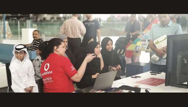 Children and parents taking part in an activity at the AmanTECH booth.