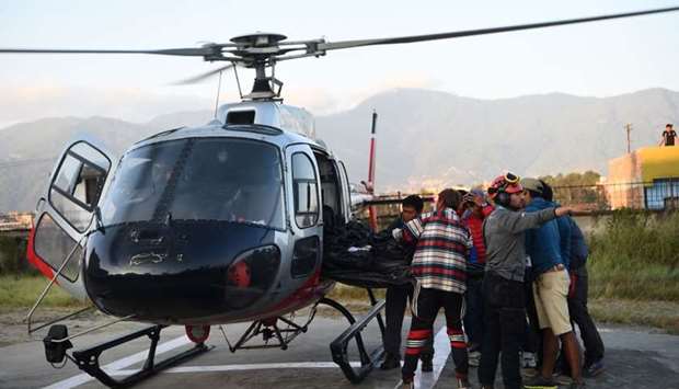 Nepali volunteers and friends remove the dead bodies of Korean and Nepali climbers recovered from Mount Gurja after being airlifted to Teaching Hospital in Kathmandu.