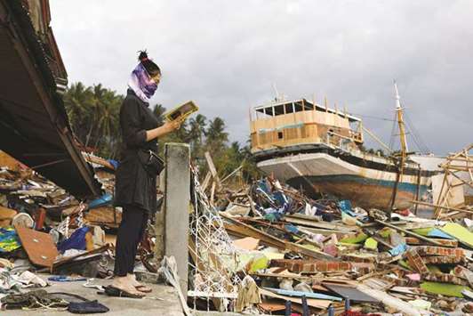 A woman visits an area hit by the tsunami on the coastline in Palu, Central Sulawesi, Indonesia.